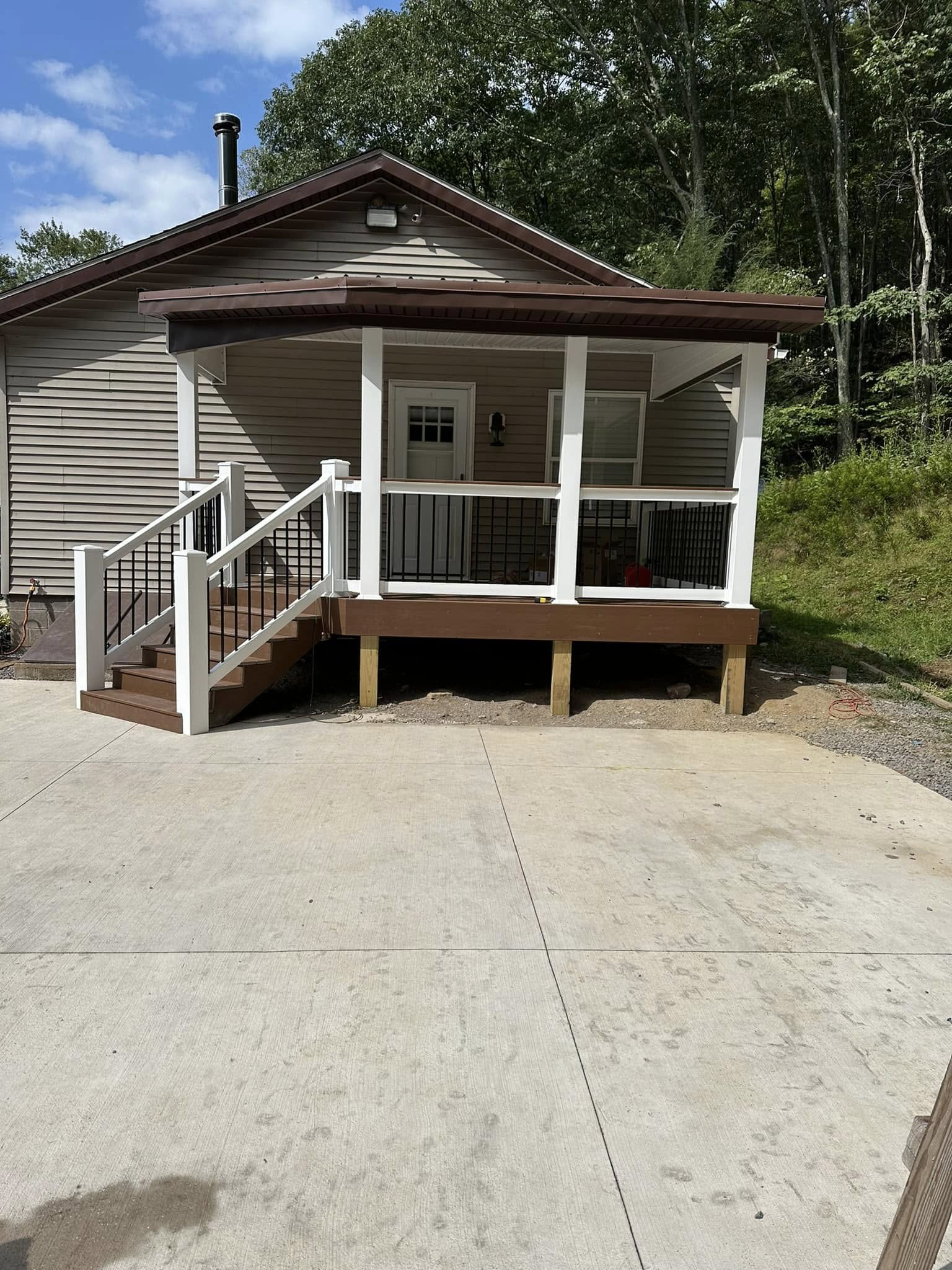 Custom covered porch with white vinyl railings.