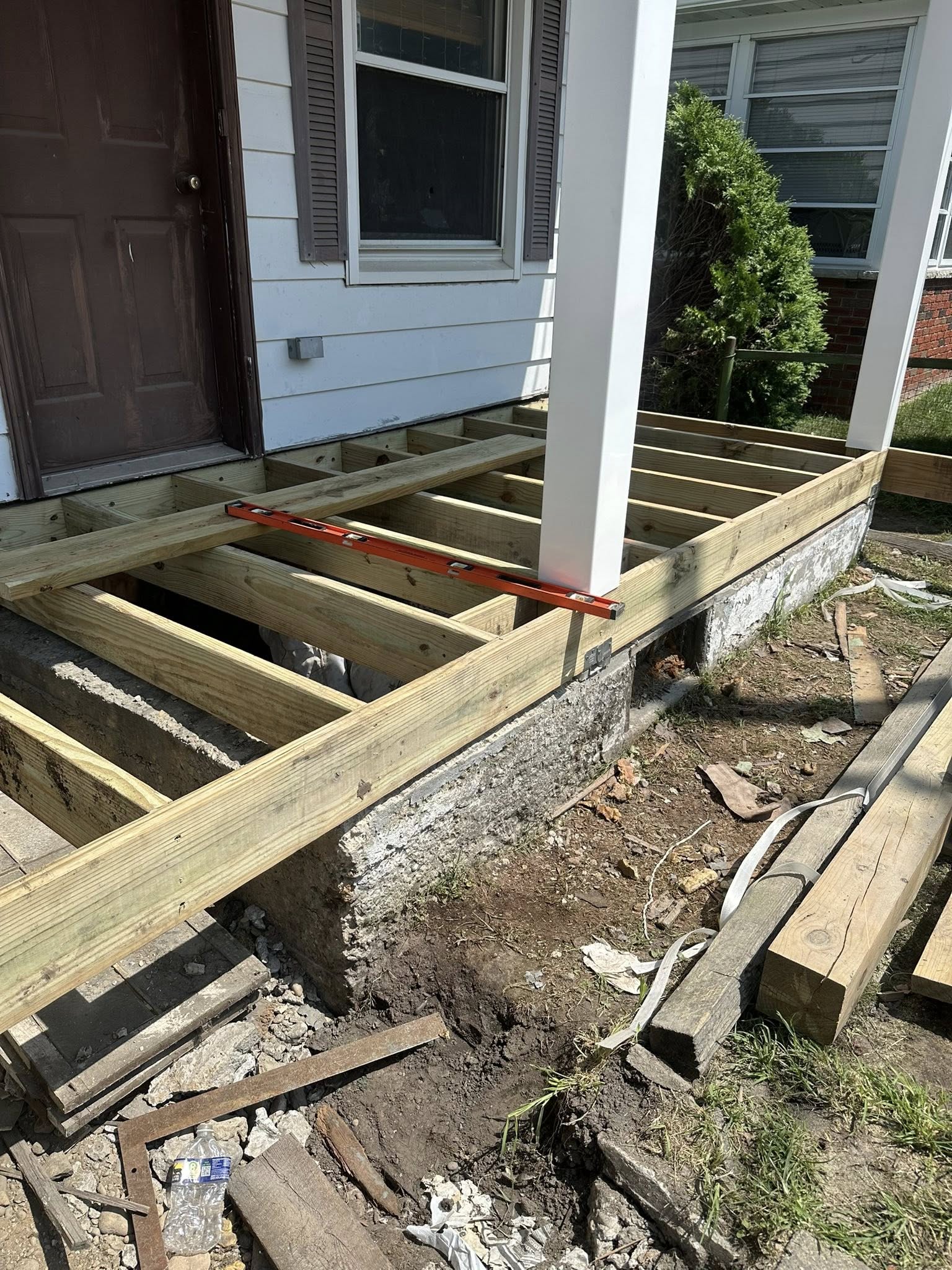 Freshly poured concrete porch and steps with wooden deck framing at a residential home in Dallas PA.